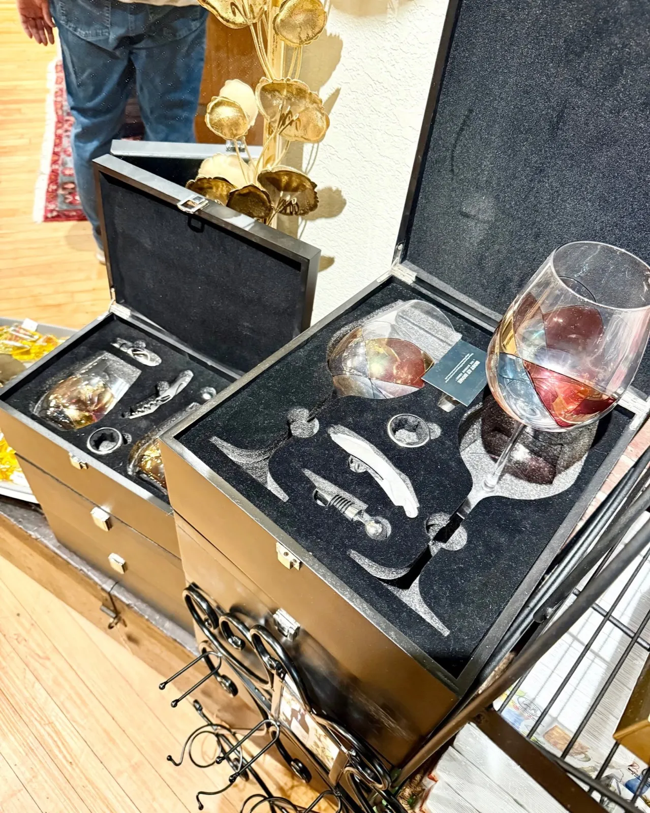 Open black wooden case holding a corkscrew, wine tools and a stemmed glass